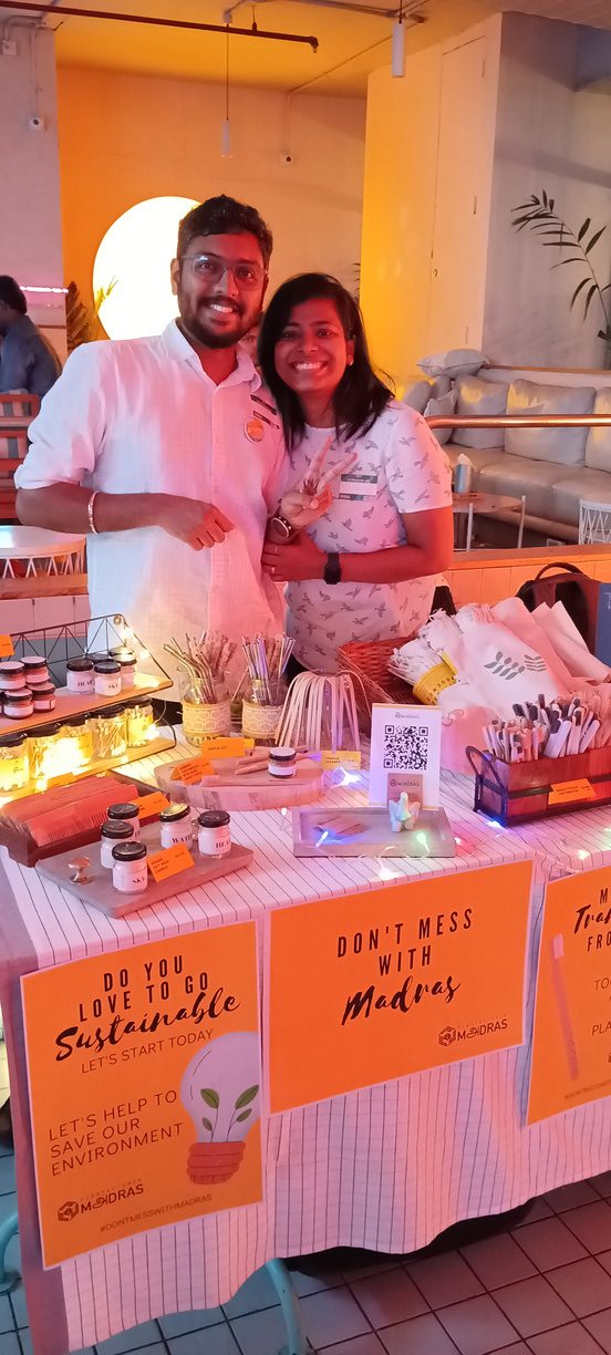 Pradeep and Divya holding Don't Mess With Madras signs at the stall
